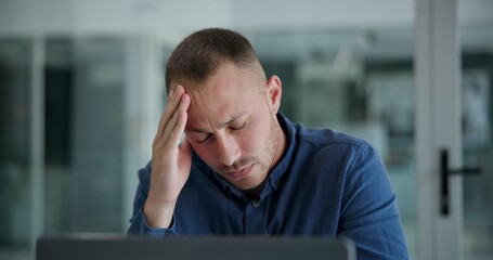 Laptop, headache and man in office, night and tired of copywriting, hand and burnout for deadline....
