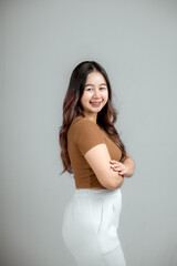 Portrait of a confident smiling girl standing with folded arms isolated.