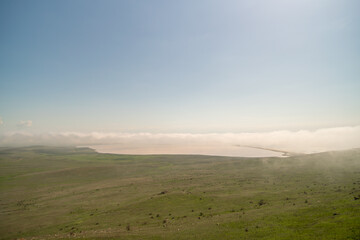 A foggy day with a large body of water in the background. The sky is clear and blue.