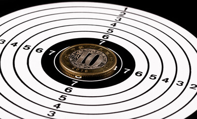 Chinese 10 yuan coin in the center of a shooting target on a black background