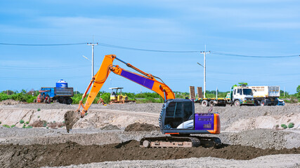 Excavator is leveling the ground and making the earth mound street for dirt trucks to enter the...