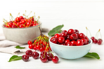 Cherries. Fresh ripe cherries with leaves on a textured wooden background. Fresh sweet organic cherry pile. Berries and fruits. Vegan. Healthy eating. Place for text. Copy space