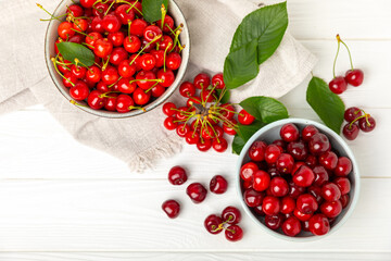 Cherries. Fresh ripe cherries with leaves on a textured wooden background. Fresh sweet organic cherry pile. Berries and fruits. Vegan. Healthy eating. Place for text. Copy space