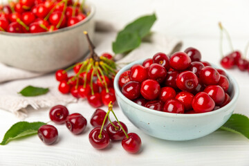 Cherries. Fresh ripe cherries with leaves on a textured wooden background. Fresh sweet organic cherry pile. Berries and fruits. Vegan. Healthy eating. Place for text. Copy space