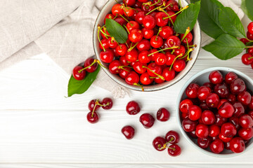 Cherries. Fresh ripe cherries with leaves on a textured wooden background. Fresh sweet organic cherry pile. Berries and fruits. Vegan. Healthy eating. Place for text. Copy space