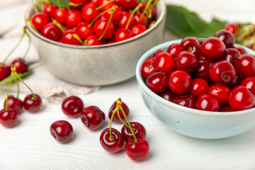Cherries. Fresh ripe cherries with leaves on a textured wooden background. Fresh sweet organic cherry pile. Berries and fruits. Vegan. Healthy eating. Place for text. Copy space