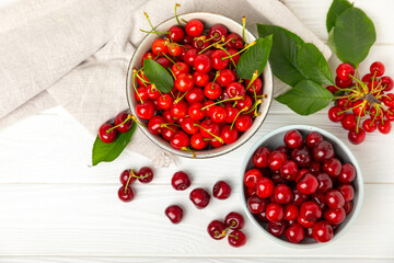 Cherries. Fresh ripe cherries with leaves on a textured wooden background. Fresh sweet organic cherry pile. Berries and fruits. Vegan. Healthy eating. Place for text. Copy space