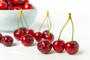 Cherries. Fresh ripe cherries with leaves on a textured wooden background. Fresh sweet organic cherry pile. Berries and fruits. Vegan. Healthy eating. Place for text. Copy space