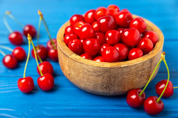 Cherries. Fresh ripe cherries with leaves on a textured wooden background. Fresh sweet organic cherry pile. Berries and fruits. Vegan. Healthy eating. Place for text. Copy space