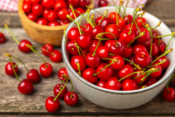 Cherries. Fresh ripe cherries with leaves on a textured wooden background. Fresh sweet organic cherry pile. Berries and fruits. Vegan. Healthy eating. Place for text. Copy space