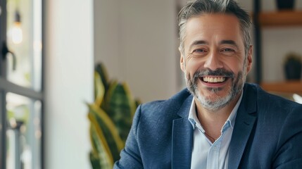 Obraz premium Picture of a confident mature businessman smiling while talking on video call looking at camera sitting in office,