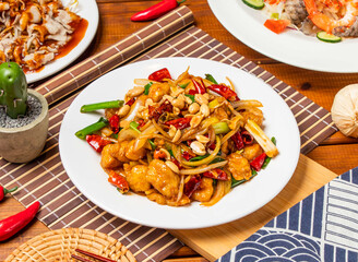 Kung Pao Chicken noodles with peanuts, spring onion red pepper and chopsticks served in dish isolated on table side view taiwanese food