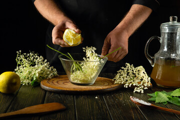 Adding lemon manually to a glass container with elderberries before making a cold drink or kvass....