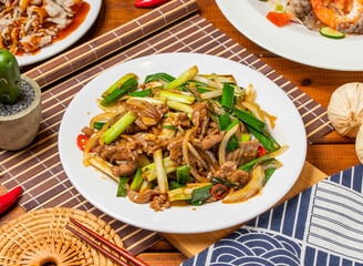 stir fried beef noodles with green onions with chopsticks served in dish isolated on table side view taiwanese food