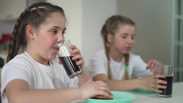 kids sit and celebrate weekend with hamburger feas enjoying every bite. weekend is marked by children laughter and shared burgers. Burgers and weekend mood children enjoy every pleasant moment.