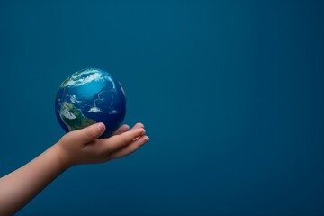 A hand holding a globe. The globe is blue and white