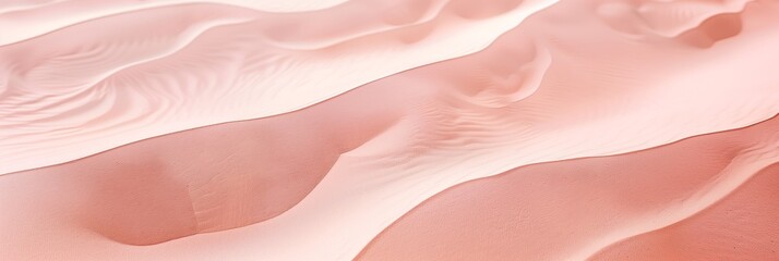 A pink sandy beach with a few small rocks. The sand is very fine and the rocks are scattered throughout the beach. The beach is calm and peaceful, with no one in sight