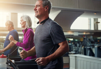 Exercise, treadmill and senior people running in gym for workout, physical health and wellness in...