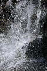 Photo of water crashing on rocks in a waterfall.