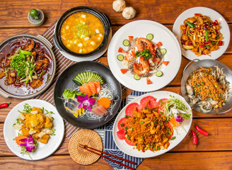 Chongqing Boiled Fish, Crab Roe and Tofu Pot, Pineapple Shrimp Balls, Comprehensive sashim, seafood salad, Kung Pao Chicken, Soft Shell Crab, Bean crispy fresh oysters with chopsticks side view