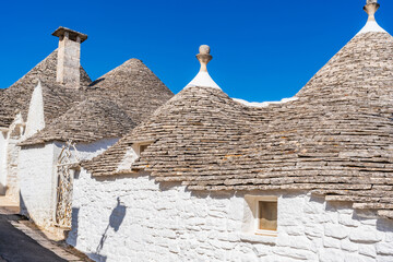 Famous historic dry stone trulli houses with conical roofs in Alberobello, Italy.