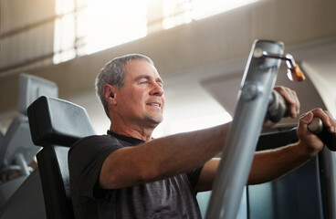 Mature, happy man and chest press with machine for workout, fitness or indoor exercise at gym....