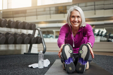 Mature woman, warm up and legs on floor, stretching and smile in portrait for workout in gym....