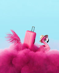 Pink flamingo with travel luggage and palm leaf on pink fluffy clouds. Summer travel concept design...