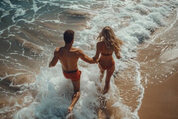 Fototapeta premium Couple Running Into Waves on Sandy Beach
