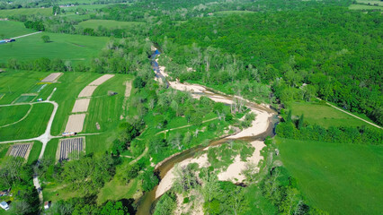 Acres of farmland with curved Lick Fork Gasconade River sandy bank running water moving to lower...