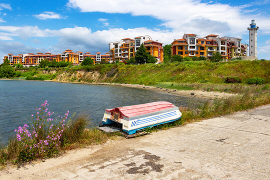 Inverted boat ashore at the Aheloy Marina, Marina Cape Hotel with the lighthouse in the background, at Aheloy, Pomorie Municipality, Burgas Province, Bulgarian Black Sea coast