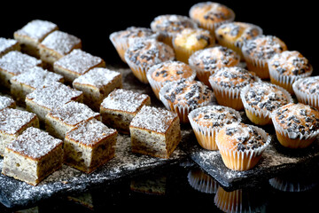 Homemade cookies and muffin with small pieces of chocolate in composition decorated with sugar on top and photographed in ambiental light.
