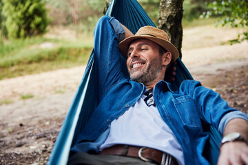 Happy adult man relaxing in hammock