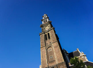 Low angle view of a church tower against blue sky