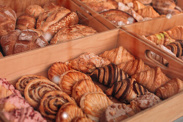 Tasty freshly baked french croissants and crispy bread. Assortment of baked goods on the counter