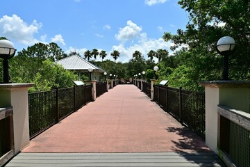 A pedestrian bridge flanked by decorative lamp posts welcomes visitors.