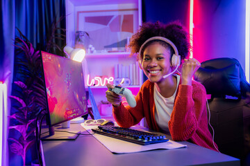 African American girl gaming streamer team winner playing online fighting with Esport wearing...