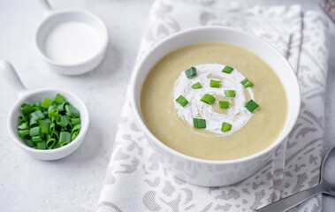 Celery greens soup with scallions and croutons in a bowl