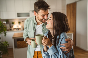 Boyfriend and girlfriend enjoy their first morning coffee at kitchen