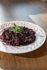 black rice dish on white plate in close-up