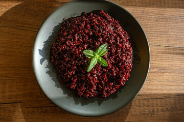 black rice dish on black plate in close-up