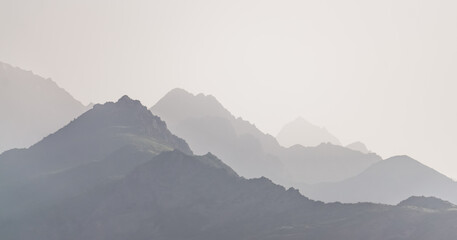 Panorama of a mountain range in the morning at dawn, tonal perspective of mountains in the morning haze in the Pamirs in Tajikistan