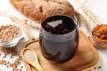 Glass of tasty kvass on white wooden background