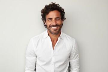 Obraz premium Portrait of a handsome man smiling at the camera while standing against grey background