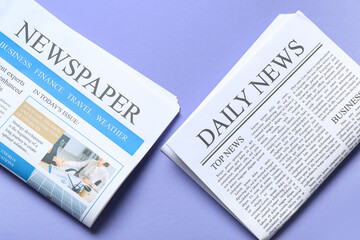 Different newspapers on lilac background