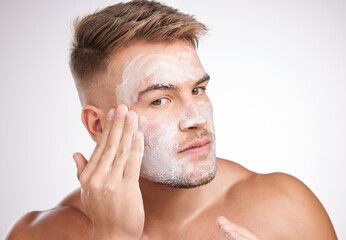 Obraz premium Beauty, skincare or man with face wash in studio for facial treatment, grooming or dermatology on white background. Wellness, cosmetic and model for healthy pores, morning routine or mask product
