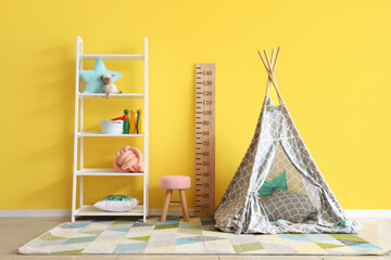 Interior of playroom with toys and teepee in kindergarten