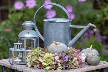 Herbst-Arrangement mit Hortensienblüten-Kranz, Kürbissen und vintage Laternen	