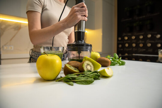 Woman with immersion blender preparing a smoothie