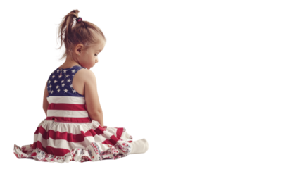Little girl sitting in a dress with American flag colors and pattern